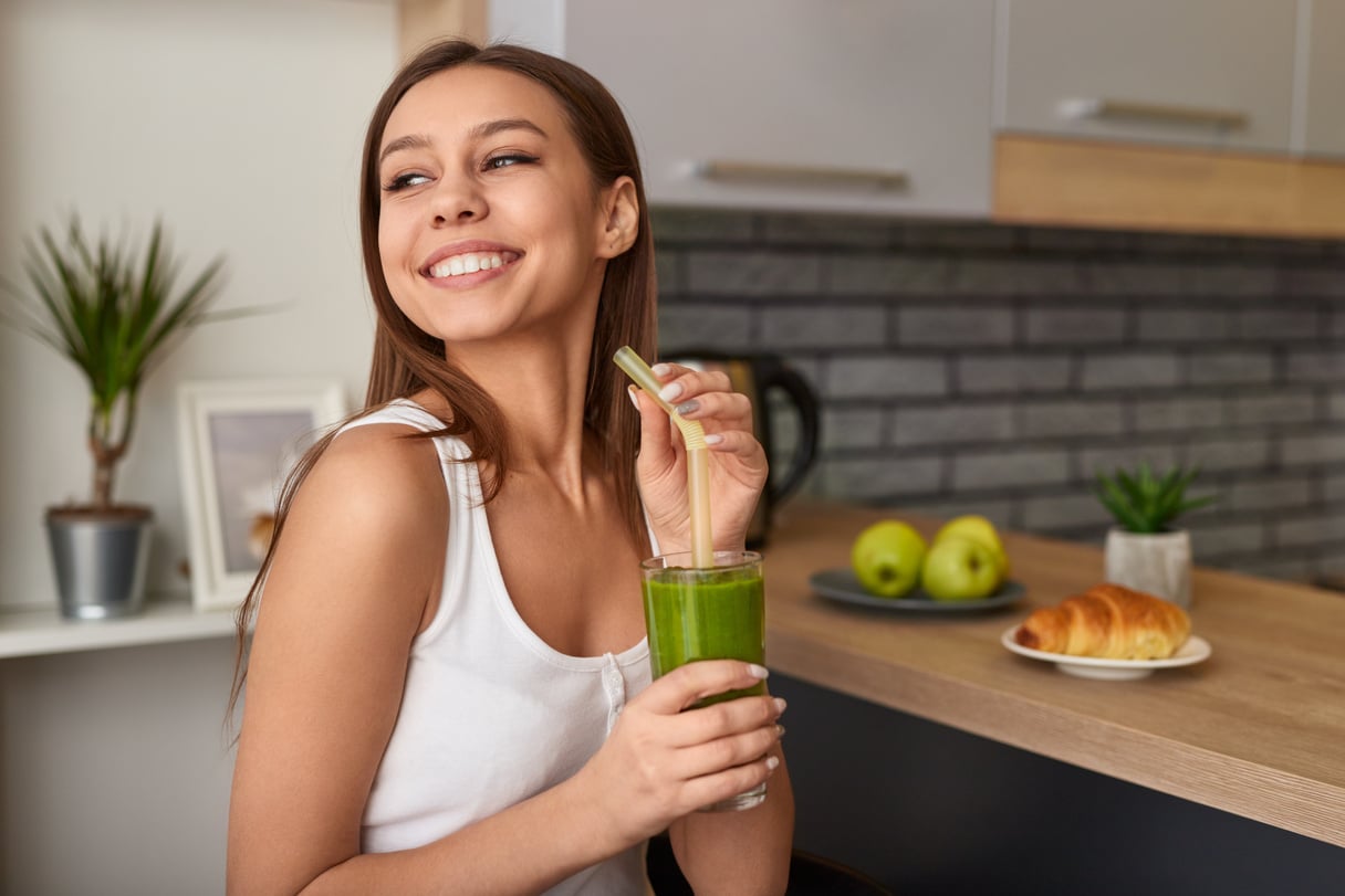 Cheerful woman enjoying detox smoothie